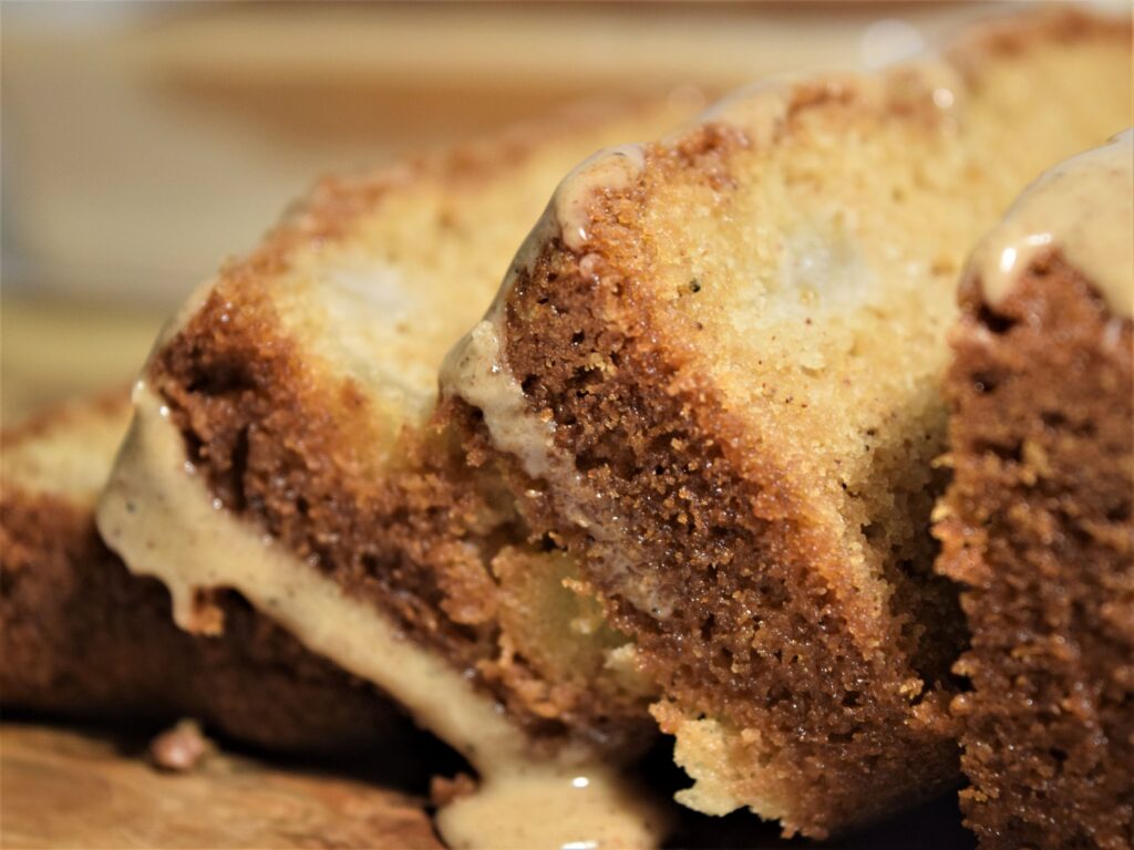 close up vanilla chai pear bread slices spice icing glaze dripping warm browns cozy baking