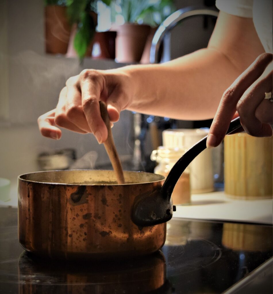 pumpkin white hot chocolate in copper pot kitchen cooking winter fall baking cozy creamy pumpkin spice stirring wooden spoon